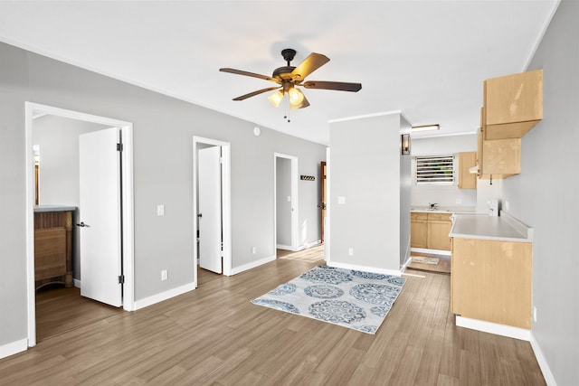 interior space featuring ceiling fan, light wood-type flooring, sink, and light brown cabinetry