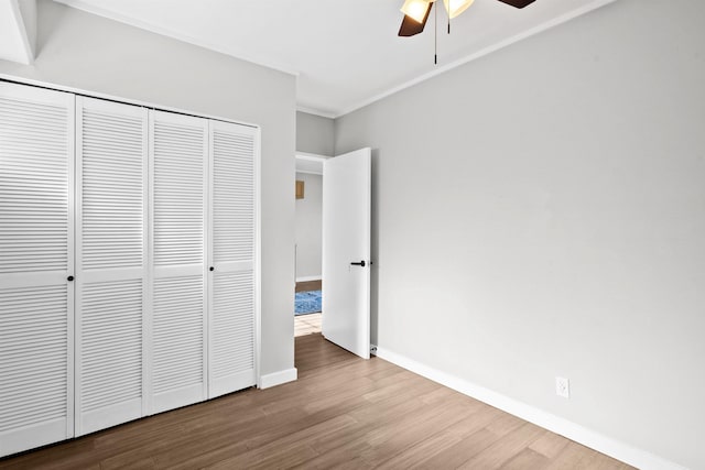 unfurnished bedroom with hardwood / wood-style floors, ceiling fan, and a closet