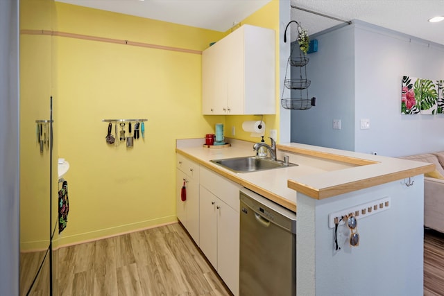 kitchen featuring stainless steel dishwasher, kitchen peninsula, and white cabinets