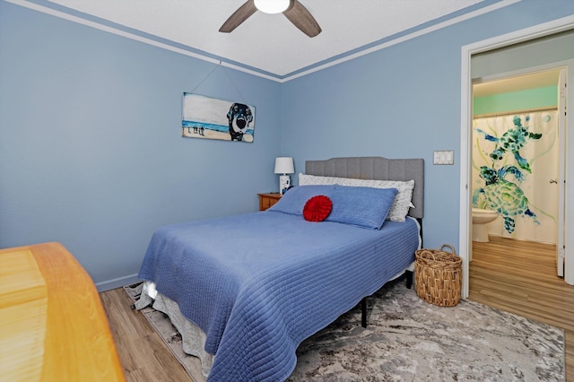 bedroom featuring ceiling fan, wood-type flooring, and ensuite bath