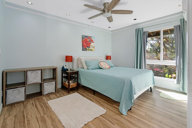 bedroom featuring multiple windows, hardwood / wood-style floors, and ceiling fan