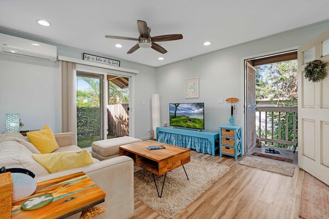 living room featuring crown molding, a wall unit AC, ceiling fan, and light wood-type flooring