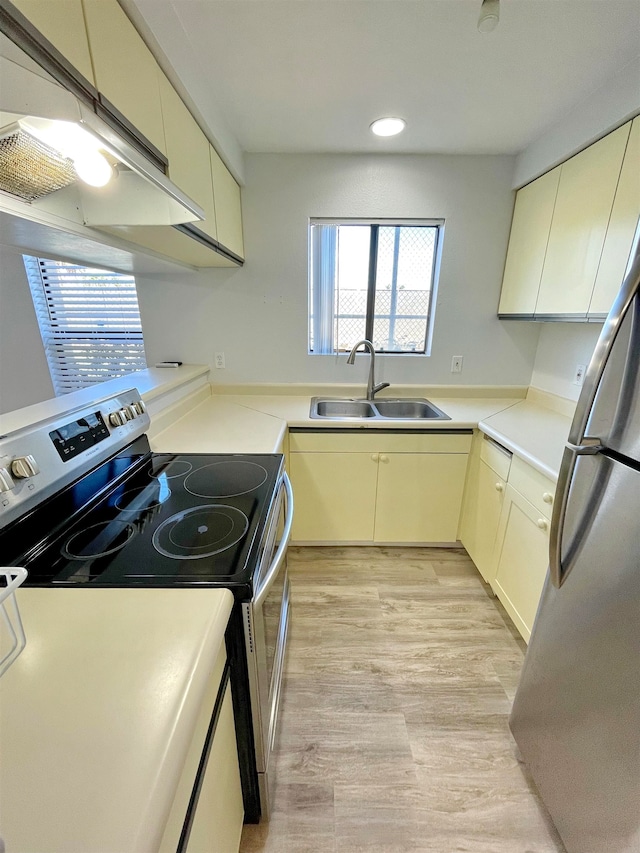 kitchen featuring stainless steel appliances, sink, and cream cabinetry