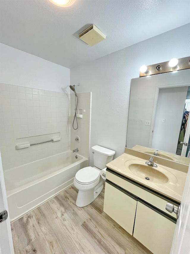 full bathroom with vanity, toilet, wood-type flooring, and washtub / shower combination