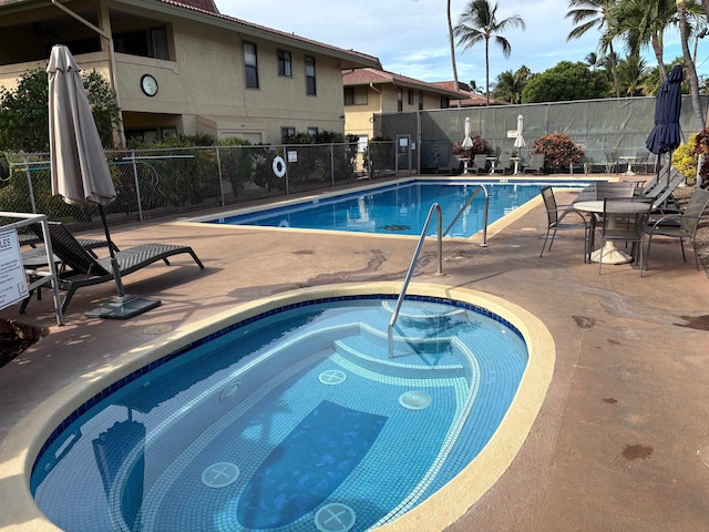 view of swimming pool with a patio and a community hot tub