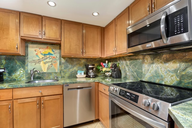 kitchen featuring light tile patterned floors, tasteful backsplash, brown cabinetry, stainless steel appliances, and a sink