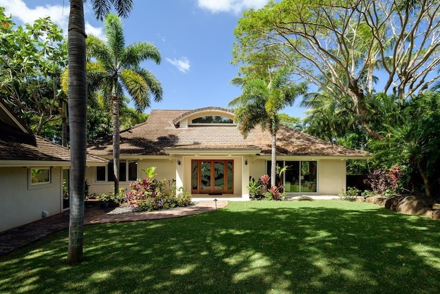 rear view of property featuring french doors and a yard