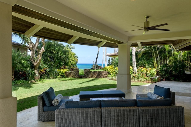 view of patio with ceiling fan, a water view, and an outdoor living space