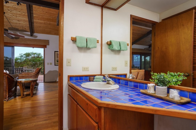 bathroom with vanity, vaulted ceiling with beams, hardwood / wood-style floors, wood ceiling, and ceiling fan