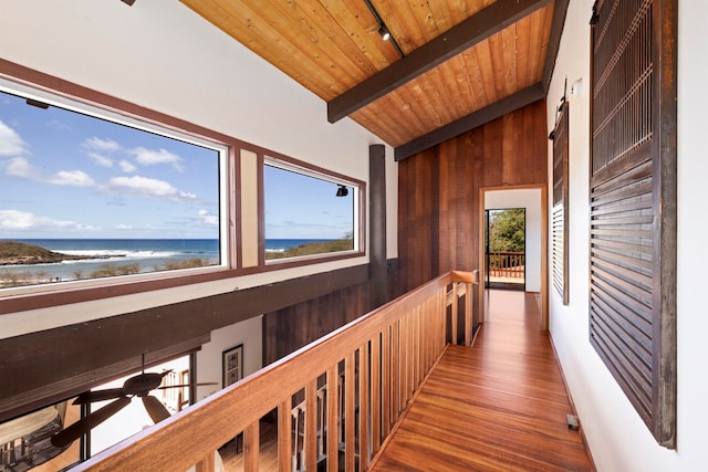 corridor with a water view, beamed ceiling, wooden walls, wood ceiling, and hardwood / wood-style floors