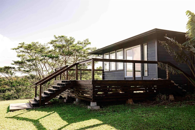 rear view of property featuring stairway and a yard