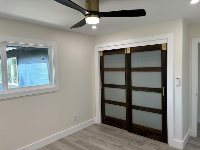 interior space featuring baseboards, light wood-type flooring, and ceiling fan