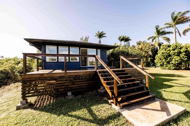 back of property with a wooden deck, a yard, and stairs