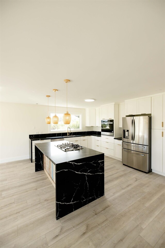 kitchen with dark countertops, light wood-type flooring, and appliances with stainless steel finishes