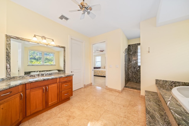 bathroom with tiled shower, vanity, and ceiling fan