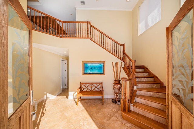 staircase featuring a high ceiling and ornamental molding