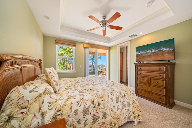 carpeted bedroom featuring ceiling fan, a raised ceiling, and access to outside