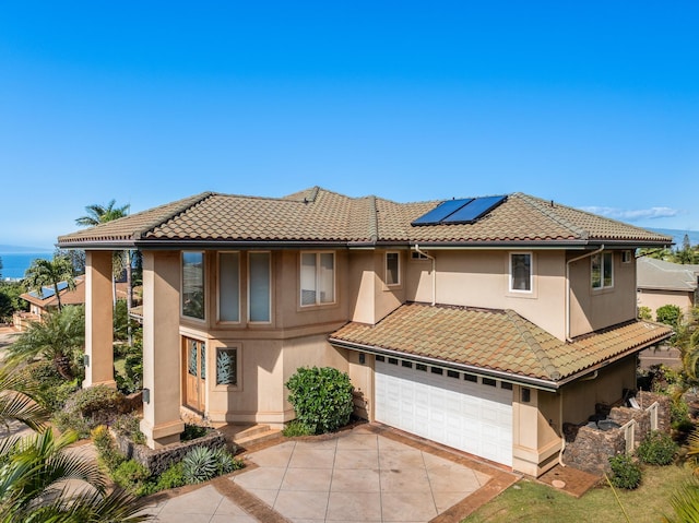 mediterranean / spanish home featuring solar panels and a garage