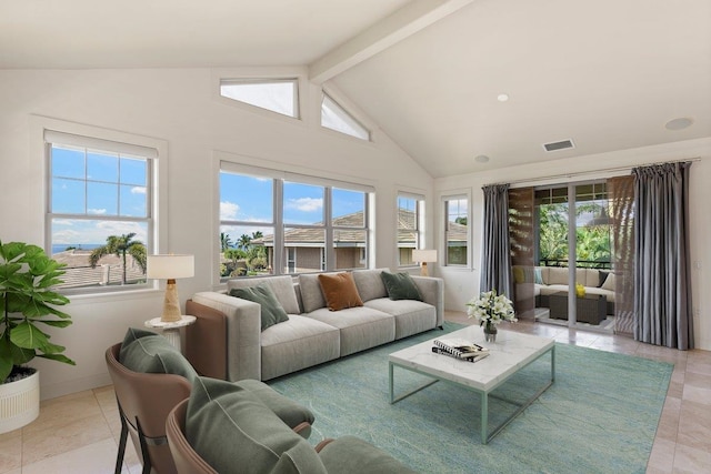 living room featuring beamed ceiling, light tile patterned flooring, and a healthy amount of sunlight