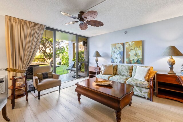 living room with floor to ceiling windows, ceiling fan, a textured ceiling, and light hardwood / wood-style flooring