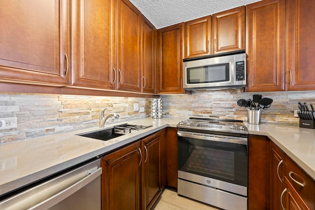 kitchen with stainless steel appliances, sink, decorative backsplash, and a textured ceiling