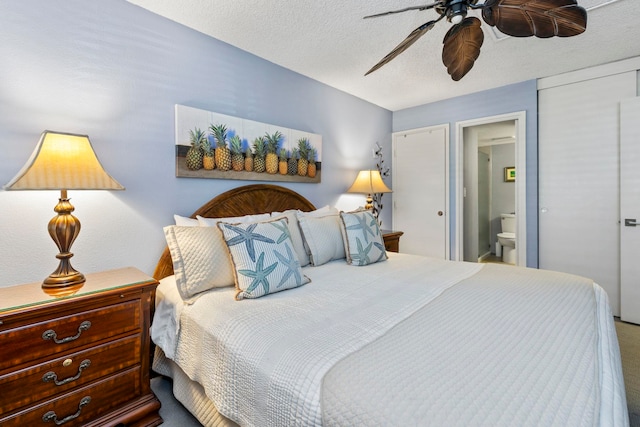 bedroom with ceiling fan, ensuite bath, and a textured ceiling