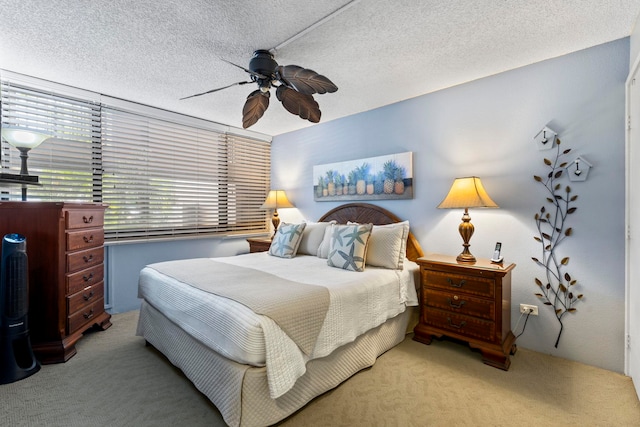 bedroom featuring ceiling fan, light colored carpet, and a textured ceiling