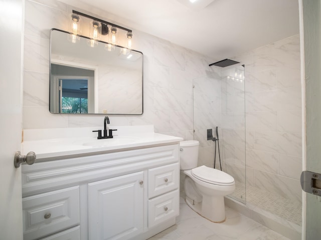 bathroom with a tile shower, vanity, tile walls, and toilet