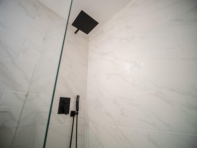 interior details featuring tiled shower