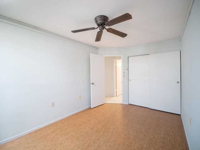 unfurnished bedroom featuring crown molding, ceiling fan, a closet, and light hardwood / wood-style floors