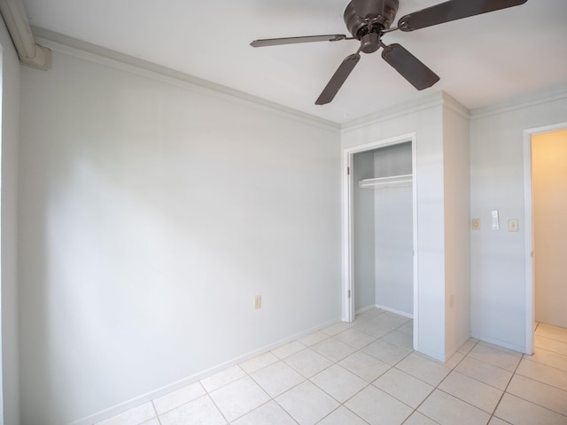 unfurnished bedroom with a closet, crown molding, light tile patterned floors, and ceiling fan