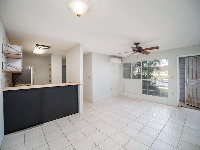 kitchen featuring kitchen peninsula, ceiling fan, a wall mounted air conditioner, and light tile patterned floors