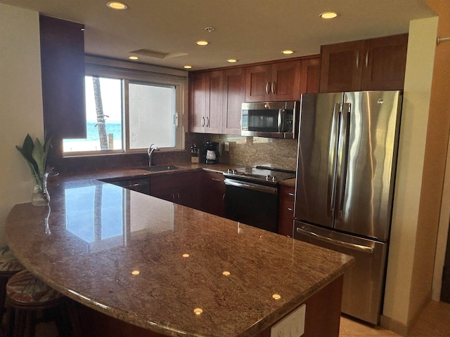 2481 Kaanapali Pkwy Unit 101A, Lahaina, HI 96761 - kitchen with appliances with stainless steel finishes, a sink, a peninsula, dark stone counters, and recessed lighting