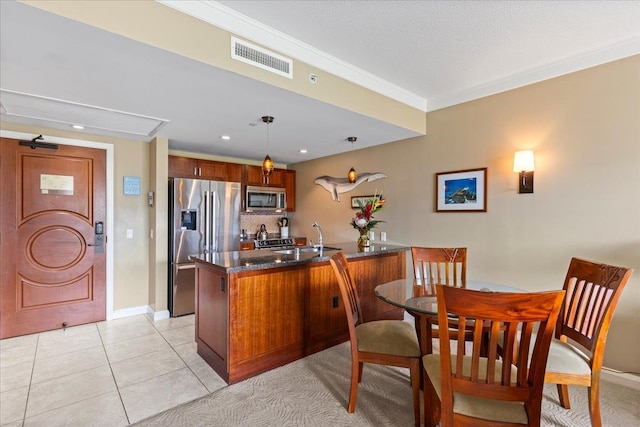 kitchen featuring kitchen peninsula, stainless steel appliances, pendant lighting, ornamental molding, and light tile patterned floors