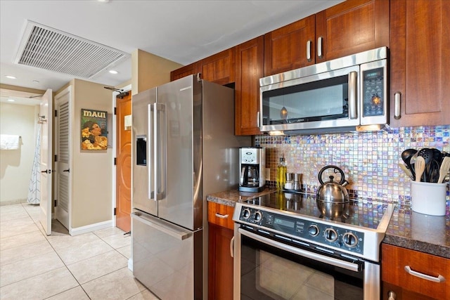 kitchen featuring appliances with stainless steel finishes, decorative backsplash, and light tile patterned floors