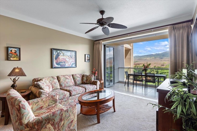 carpeted living room featuring ceiling fan, crown molding, and a textured ceiling