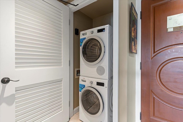 clothes washing area featuring stacked washer and clothes dryer