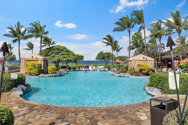 view of pool featuring a gazebo, pool water feature, and a water view