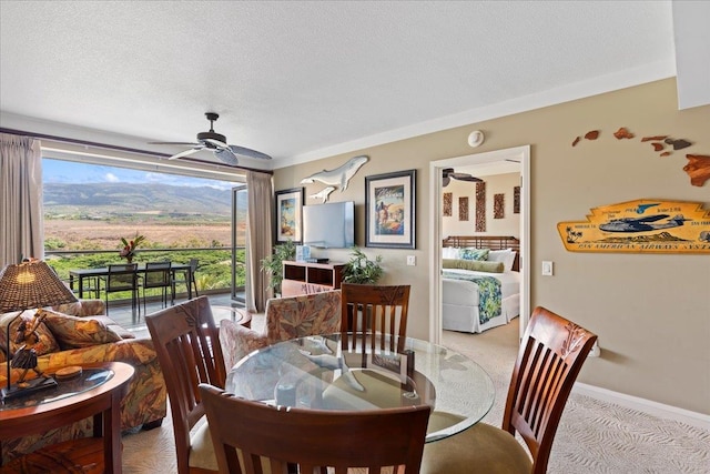 dining space with crown molding, a textured ceiling, light colored carpet, and ceiling fan