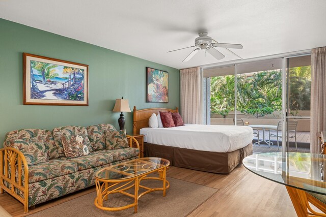 bedroom with floor to ceiling windows, access to exterior, wood-type flooring, and ceiling fan