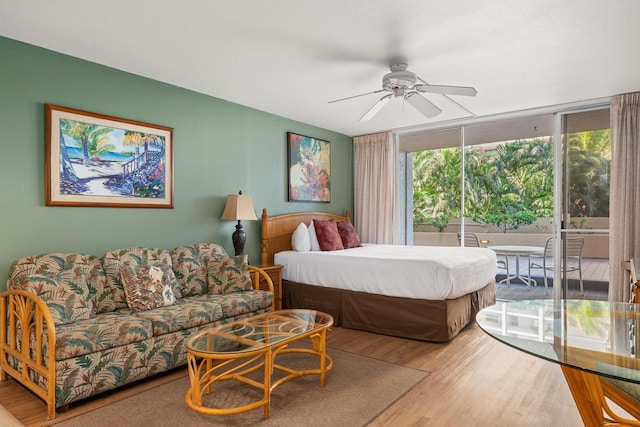 bedroom with floor to ceiling windows, access to exterior, wood-type flooring, and ceiling fan