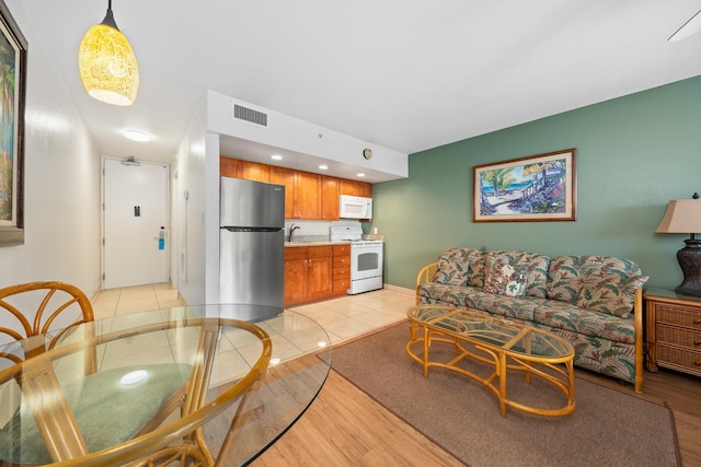 living room with light hardwood / wood-style floors and sink