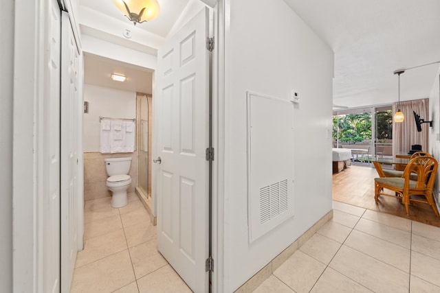 hall featuring tile walls and light tile patterned flooring