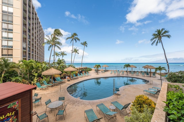 view of swimming pool with a patio area and a water view