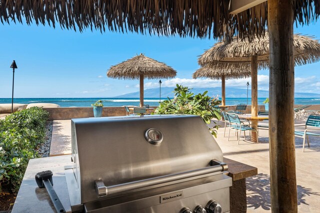 view of patio featuring area for grilling, a water and mountain view, and grilling area