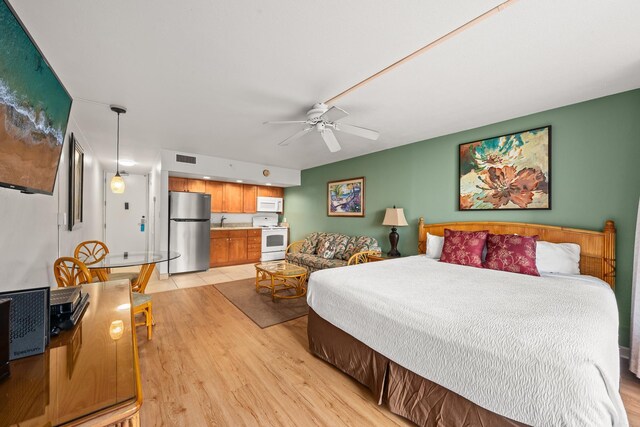 bedroom with ceiling fan, sink, stainless steel fridge, and light hardwood / wood-style flooring