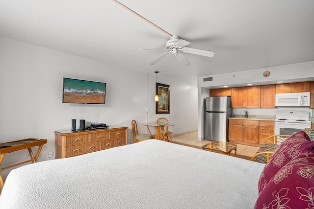 bedroom with sink, ceiling fan, light tile patterned floors, and stainless steel fridge