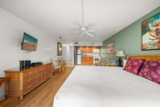 bedroom featuring ceiling fan, light hardwood / wood-style floors, and stainless steel fridge