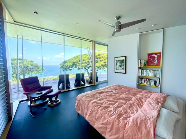 bedroom with access to outside, a water view, ceiling fan, and a wall of windows