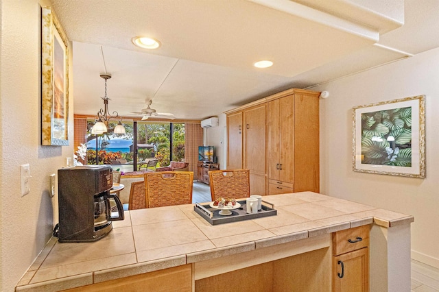 4327 Lower Honoapiilani Rd Unit 101B, Lahaina, HI 96761 - kitchen featuring a ceiling fan, baseboards, a wall unit AC, tile countertops, and recessed lighting
